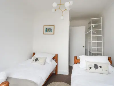 two beds in a room with white walls at Arran House in Barmouth