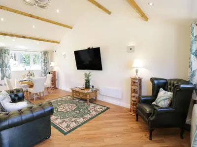 a living room with leather furniture and a flat screen tv at Fairfield in Ludlow