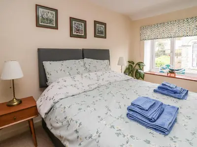 a bedroom with a bed with blue towels on it at Cysgod Y Coed in Machynlleth