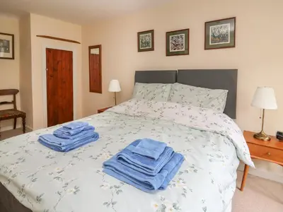 a bedroom with a bed with blue towels on it at Cysgod Y Coed in Machynlleth
