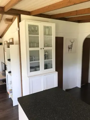 a kitchen with white cabinets and a black counter top at Pheasant Lodge in Builth Wells
