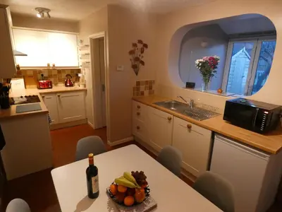 a kitchen with a table with a bottle of wine at Shepherds Cottage in Shrewsbury