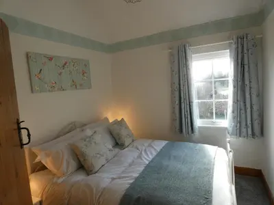a bedroom with a bed and a window at Shepherds Cottage in Shrewsbury