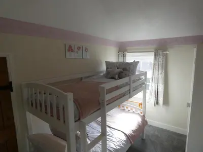 a white bunk bed in a room with a window at Shepherds Cottage in Shrewsbury
