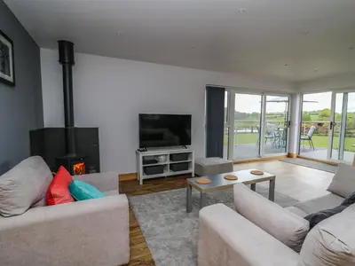 a living room with two couches and a tv at Llyn Cae Ty Nant Fishery Holiday Let in Lampeter