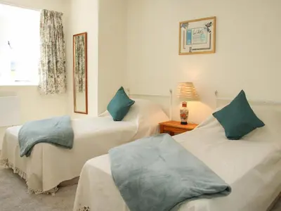 a bedroom with two beds with blue pillows at The Stables in Shrewsbury