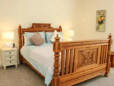 a bedroom with a large wooden bed with two lamps at The Stables in Shrewsbury