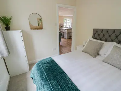 a bedroom with a large white bed with a mirror at 2 The Villa in Ludlow
