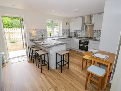 a kitchen with a large island with bar stools at 2 The Villa in Ludlow
