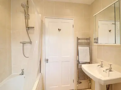 a white bathroom with a sink and a shower at Artro View in Llanbedr