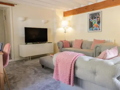 a living room with a couch and a flat screen tv at The Old Smithy Cottage in Blaenau-Ffestiniog