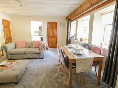 a living room with a table and a couch at The Old Smithy Cottage in Blaenau-Ffestiniog