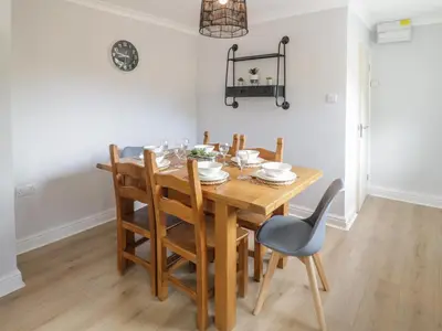 a dining room with a wooden table and chairs at Bryn Teg in Oswestry