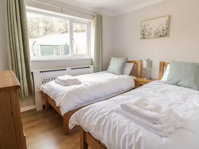 two twin beds in a room with a window at Bryn Teg in Oswestry