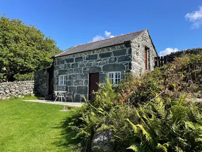 an old stone cottage with a grass yard at Gelli Bach at Gelli Las in Llanbedr