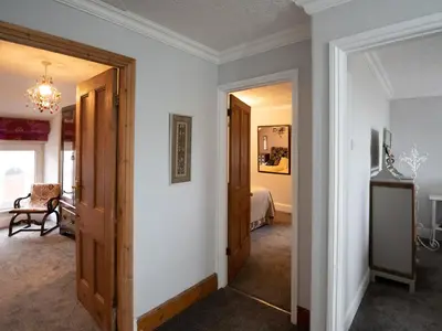 a hallway with two doors and a room with a bed at Galeri Harlech Townhouse in Harlech
