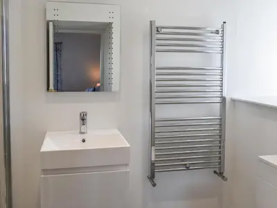 a white bathroom with a sink and a mirror at Bryn Y Felin in Dyffryn