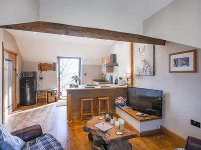 a living room with a table and a kitchen at The Red House - Uk39234 in Minsterley