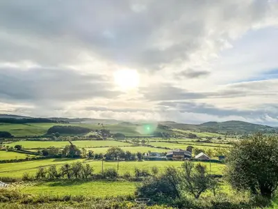 a green field with the sun in the sky at The Red House - Uk39234 in Minsterley