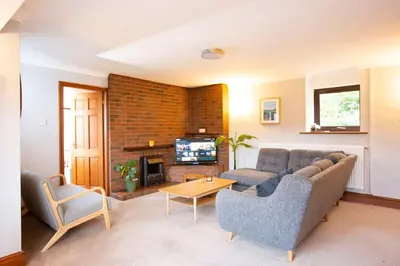 a living room with a couch and a tv at Hillside Cottage, countryside views near Llangollen in Corwen