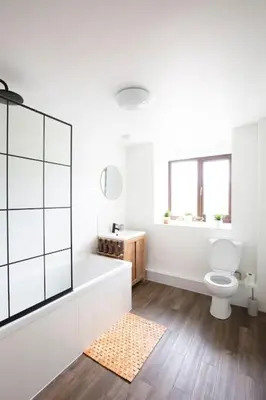 a bathroom with a tub and a toilet and a sink at Hillside Cottage, countryside views near Llangollen in Corwen