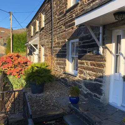 a stone house with potted plants in front of it at Ty Canol Maentwrog, Snowdonia Nr Zip World in Maentwrog