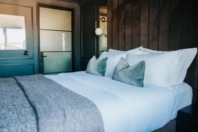 a bedroom with a large white bed with blue pillows at Y Seler in Aberaeron