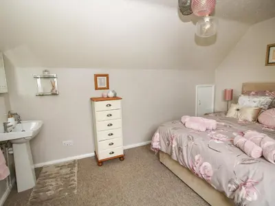 a small bedroom with a bed and a sink at Roseland in Ludlow