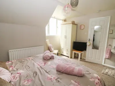 a bedroom with a bed with two pink pillows on it at Roseland in Ludlow