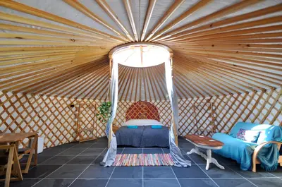 a room with a bed in a yurt at Spacious heated Yurt with Hot tub, 5 mins to beach in Bow Street