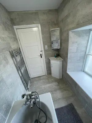 a bathroom with a tub and a white door at The Bala House in Bala