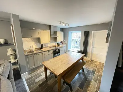 a kitchen with a wooden table in a room at The Bala House in Bala