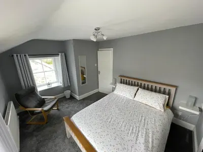 a bedroom with a bed and a chair and a window at The Bala House in Bala