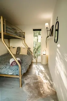 a bedroom with a bunk bed and a rug at Stay Wild Retreats 'Glamping Pods and Tents' in Wrexham