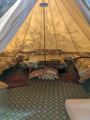 a tent with a bunch of beds in it at Stay Wild Retreats 'Glamping Pods and Tents' in Wrexham
