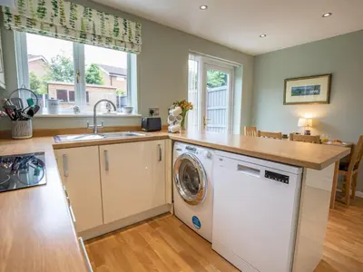 a kitchen with a washer and dryer in it at Cheerful and modern one bedroom home with parking - Pass the Keys in Shrewsbury