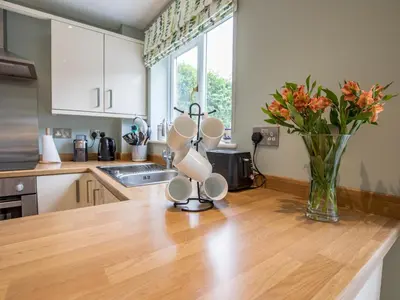 a kitchen with a counter with a vase of flowers at Cheerful and modern one bedroom home with parking - Pass the Keys in Shrewsbury