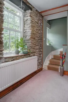a room with stairs and a stone wall at The Green Door Vegan B&B in Llanon