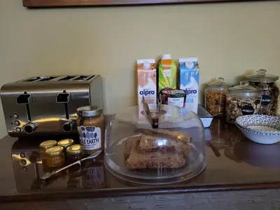 a counter top with a food in a plastic container and ingredients at The Green Door Vegan B&B in Llanon
