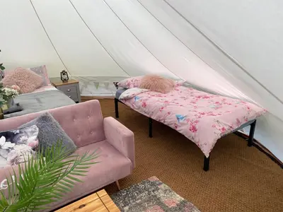 a room with a couch and a chair in a tent at River View Glamping in Llandovery