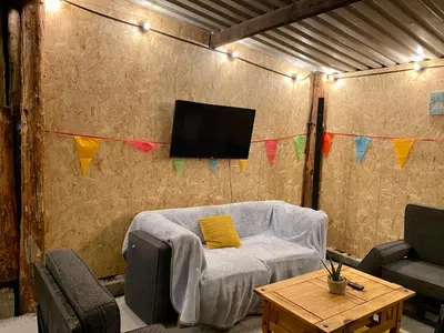 a living room with a couch and a tv on a wall at River View Glamping in Llandovery