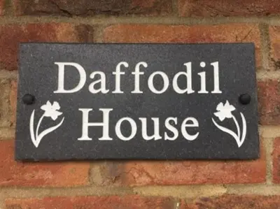 a sign for a daffodil house on a brick wall at Daffodil House , West Wales in Llandovery