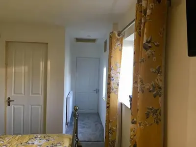 a bedroom with a bed and a door to a hallway at Daffodil House , West Wales in Llandovery