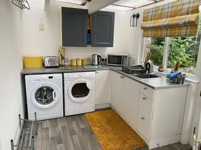 a kitchen with a washing machine and a sink at Daffodil House , West Wales in Llandovery