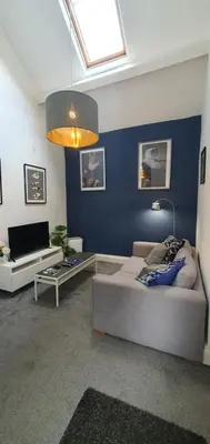 a living room with a couch and a tv at Cosy Spring Cottage at Pen Y Coed Hall in Dolgellau