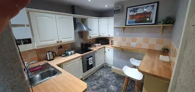a small kitchen with white cabinets and a sink at Cosy Spring Cottage at Pen Y Coed Hall in Dolgellau