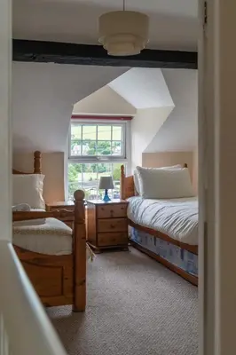 a bedroom with two beds and a window at Glasfryn Cottage Dolgellau in Dolgellau