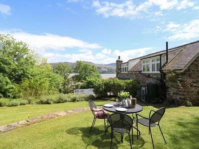 a table and chairs in the yard of a house at Bodowen Coach House in Barmouth