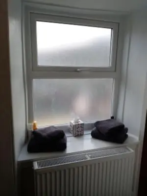 a window with two towels and a radiator under it at Bridge View Victorian Townhouse Central Aberystwyth Sleeps 6 in Aberystwyth