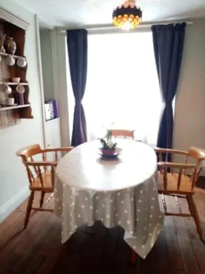a dining room with a white table and chairs at Bridge View Victorian Townhouse Central Aberystwyth Sleeps 6 in Aberystwyth